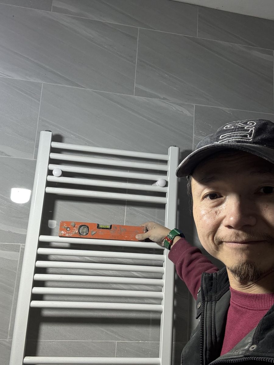Dickson checking a newly fitted towel rail with a spirit level